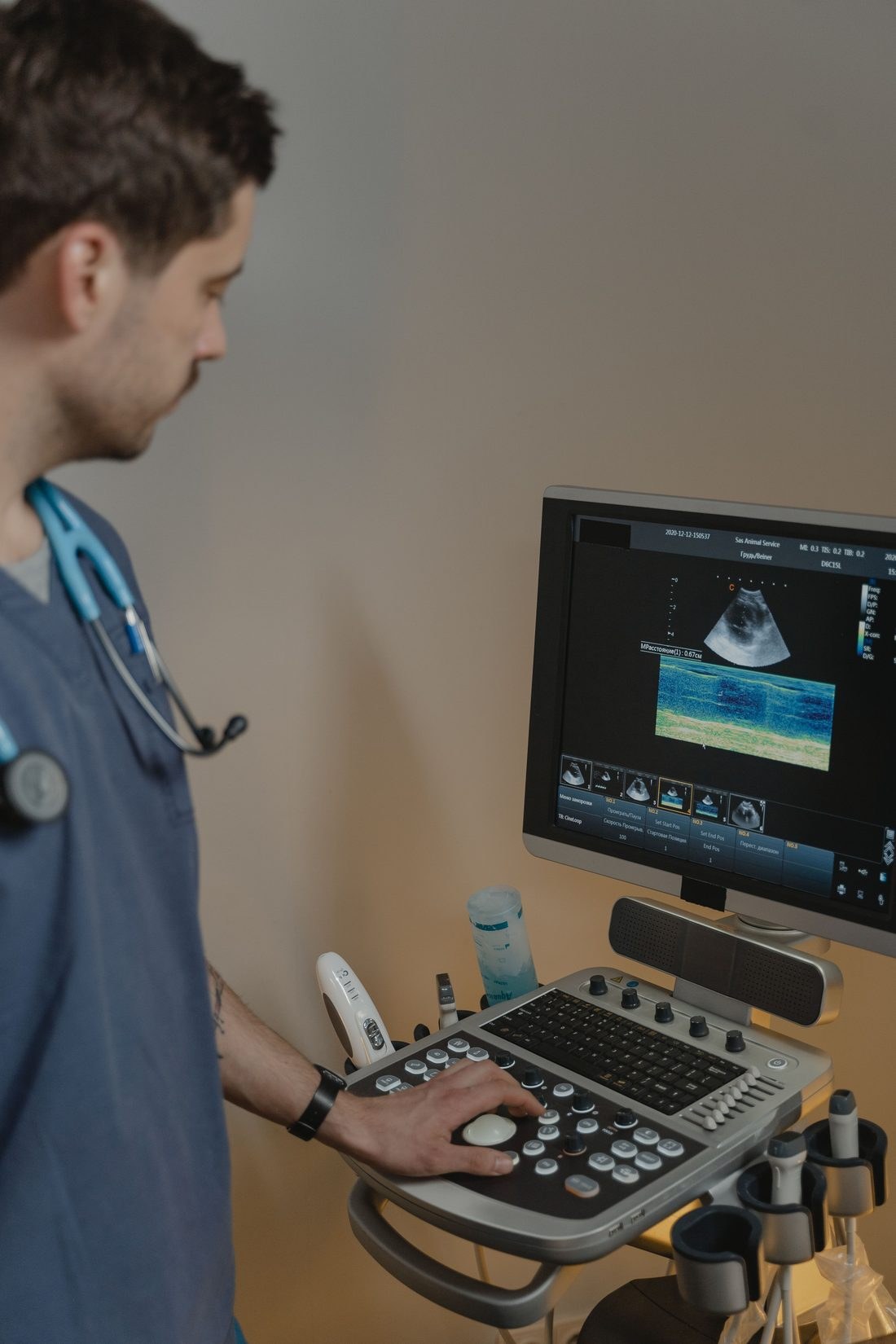 Sonographer reviewing ultrasound images on screen during an exam